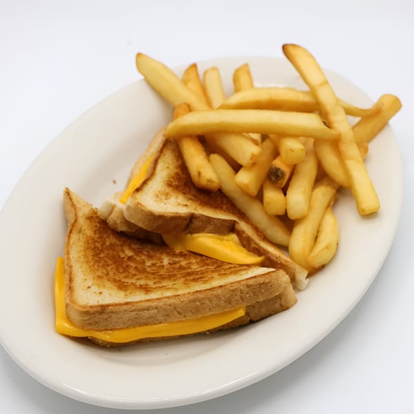 Grilled cheese sandwich with melted American cheese and a side of golden french fries on a white plate.